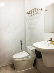 a white bathroom with a toilet and a sink at T&N home Ayutthaya in Phra Nakhon Si Ayutthaya