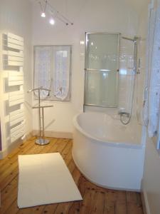 y baño blanco con bañera y ducha. en Maison l'épicurienne, en Les Sables-dʼOlonne