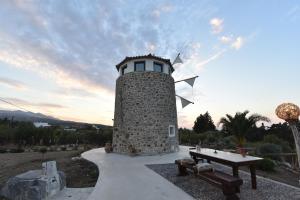 a stone lighthouse with a table in front of it at Milos Maison in (( Kermetés ))