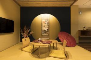 a room with a table and two chairs and a table at Guesthouse Raku in Kyoto