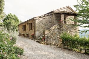 a stone house with flowers on the side of it at Casa Rancacci in Mercatale