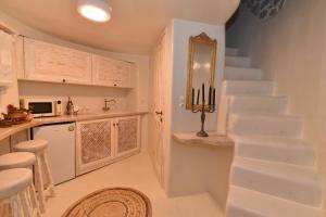 a white staircase in a kitchen with a stair case at Milos Maison in (( Kermetés ))