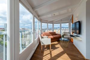sala de estar con ventanas grandes y sofá en Skyflats Vienna - Belle View, en Viena