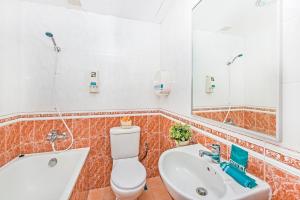 ein Badezimmer mit Toilette, Waschbecken und Spiegel in der Unterkunft Hotel 81 Cosy in Singapur