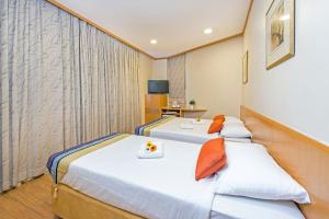2 camas en una habitación de hotel con TV en Hotel 81 Sakura, en Singapur