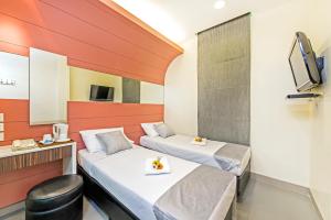 a hotel room with two beds and a television at Hotel 81 Rochor in Singapore
