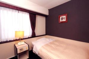 a hotel room with a bed and a window at Kagoshima Kuko Hotel in Kirishima