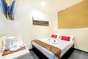 um quarto de hotel com uma cama com almofadas vermelhas em Hotel 81 Selegie em Singapura