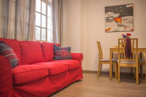 a red couch in a living room with a table at Apartamento Padilla Playa Huelin in Málaga
