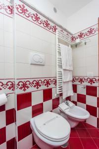 a red and white bathroom with a toilet and a sink at Hotel Bonadies in Ravello