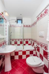 a red and white bathroom with a toilet and a sink at Hotel Bonadies in Ravello