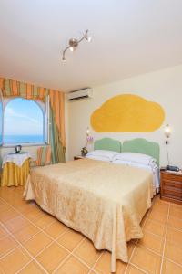 a bedroom with a large bed and a large window at Hotel Bonadies in Ravello