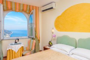 a bedroom with a bed and a large window at Hotel Bonadies in Ravello