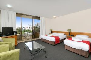 a hotel room with two beds and a tv and a couch at Summit Apartments in Brisbane