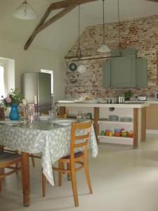 uma cozinha com mesa e cadeiras num quarto em Job's Mill Cottage em Warminster