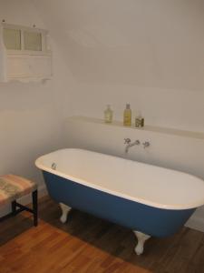 a blue and white bath tub in a bathroom at Job's Mill Cottage in Warminster