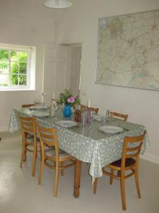 a dining room with a table with chairs and a map at Job's Mill Cottage in Warminster +4 photos