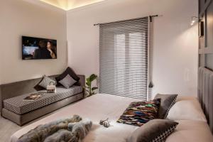 a bedroom with a bed and a couch and a window at Almaìt in Rome