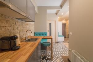a kitchen with a sink and a counter with blue stools at Romantic Jacuzzi Belleview Studio in Sinaia