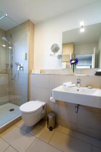 ein Bad mit einem WC, einem Waschbecken und einer Dusche in der Unterkunft Hotel Seepark Garni in Überlingen