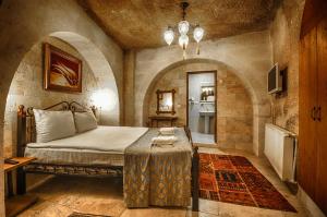 a bedroom with a bed and a table in it at Nomads Cave Hotel & Rooftop in Göreme