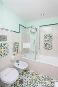 a bathroom with a toilet and a tub and a sink at Hotel Bonadies in Ravello