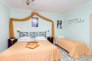 a bedroom with two beds and two pictures on the wall at Hotel Bonadies in Ravello