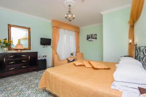 a bedroom with a bed and a mirror and a dresser at Hotel Bonadies in Ravello