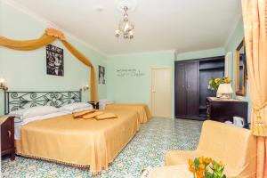 a hotel room with two beds and a chair at Hotel Bonadies in Ravello