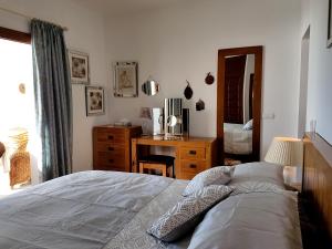 a bedroom with a bed and a desk and a mirror at Villa Sellares in Mojácar