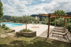a pool with a bench and a wooden pergola at Casa Rancacci in Mercatale