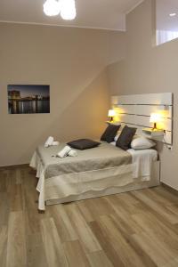 una camera con un grande letto e un pavimento in legno di Central Station Garibaldi a Napoli