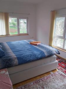 a bed in a room with two windows at Sam guest house in Jajce
