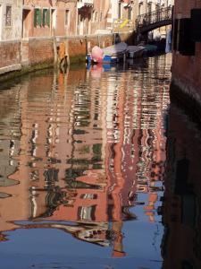 a reflection of buildings in the water of a canal at b&b allo squero in Venice