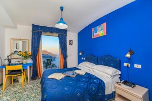 a blue bedroom with a blue bed and a desk at Hotel Bonadies in Ravello