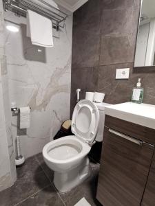 West House Apartments-Mar Mikhael في بيروت: حمام به مرحاض أبيض ومغسلة