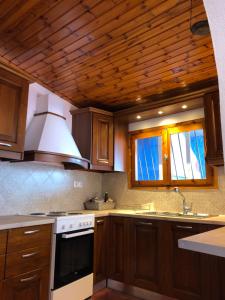 uma cozinha com armários de madeira e um forno de fogão branco em Villa Nanita em Pláka