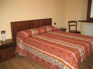 um quarto com uma cama grande e uma cabeceira em madeira em Deliziosa casetta em Valpelline