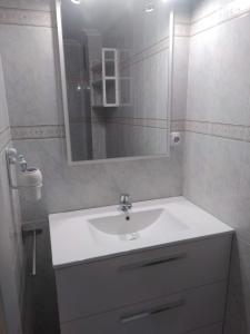 ein Badezimmer mit einem weißen Waschbecken und einem Spiegel in der Unterkunft Torrenostra de LUX in Torrenostra