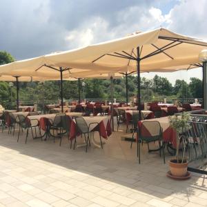 a restaurant with tables and chairs under umbrellas at Affittacamere Battistoli in Costermano
