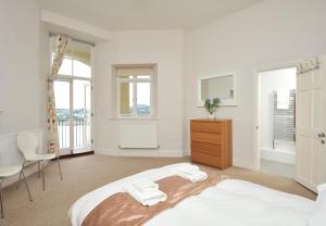 a bedroom with a bed and a dresser at Astor House in Torquay