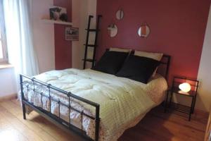 1 dormitorio con cama y pared roja en chambre à la campagne Saint André de Chalencon, en Saint-André-de-Chalençon