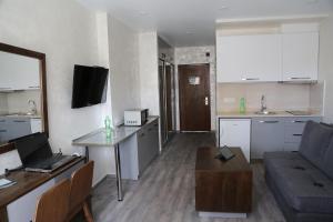 a small living room with a couch and a kitchen at Family Apartment in Batumi