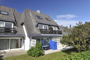 ein Haus mit einem grauen Dach und einer Terrasse in der Unterkunft Nordseesonne I in Wenningstedt-Braderup