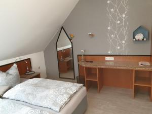 a bedroom with a bed and a desk and a mirror at Hotel Sonnenschein in Bad Liebenwerda