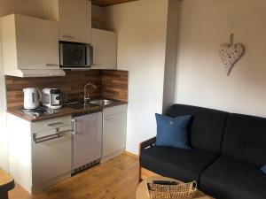 a living room with a couch and a kitchen at Ferienwohnung Basthorst in Basthorst