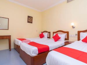 a room with two beds with red and white sheets at FULLY HOTEL JOHOR JAYA in Johor Bahru