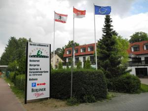 a sign with three flags in front of a building at Waldhotel Wandlitz in Wandlitz +4 photos