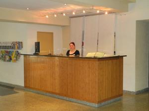 a woman standing behind a counter in a room at Waldhotel Wandlitz in Wandlitz