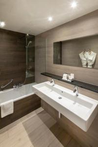 a bathroom with a sink and a shower and a tub at Hotel Auberge St. Pol in Knokke-Heist